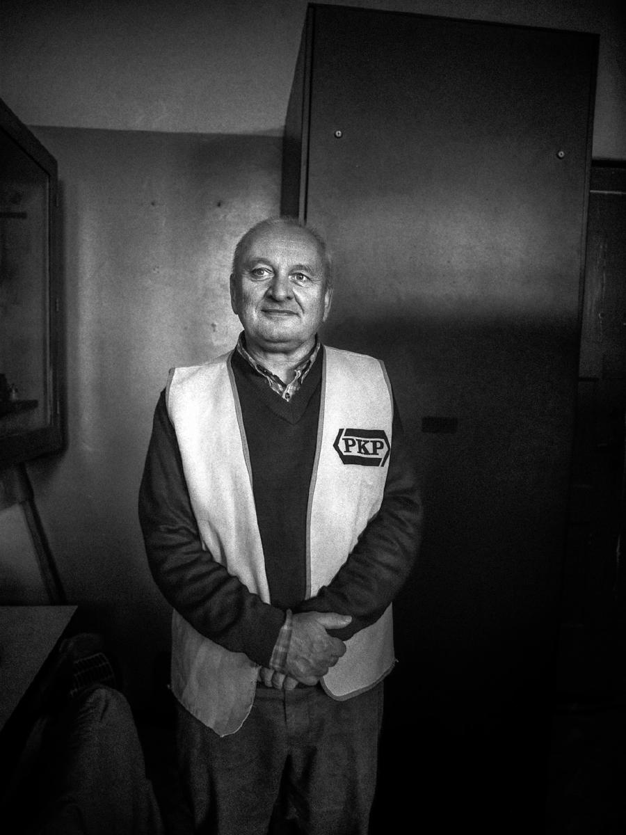 Zwart-witportret van een man in een vest met PKP-logo
