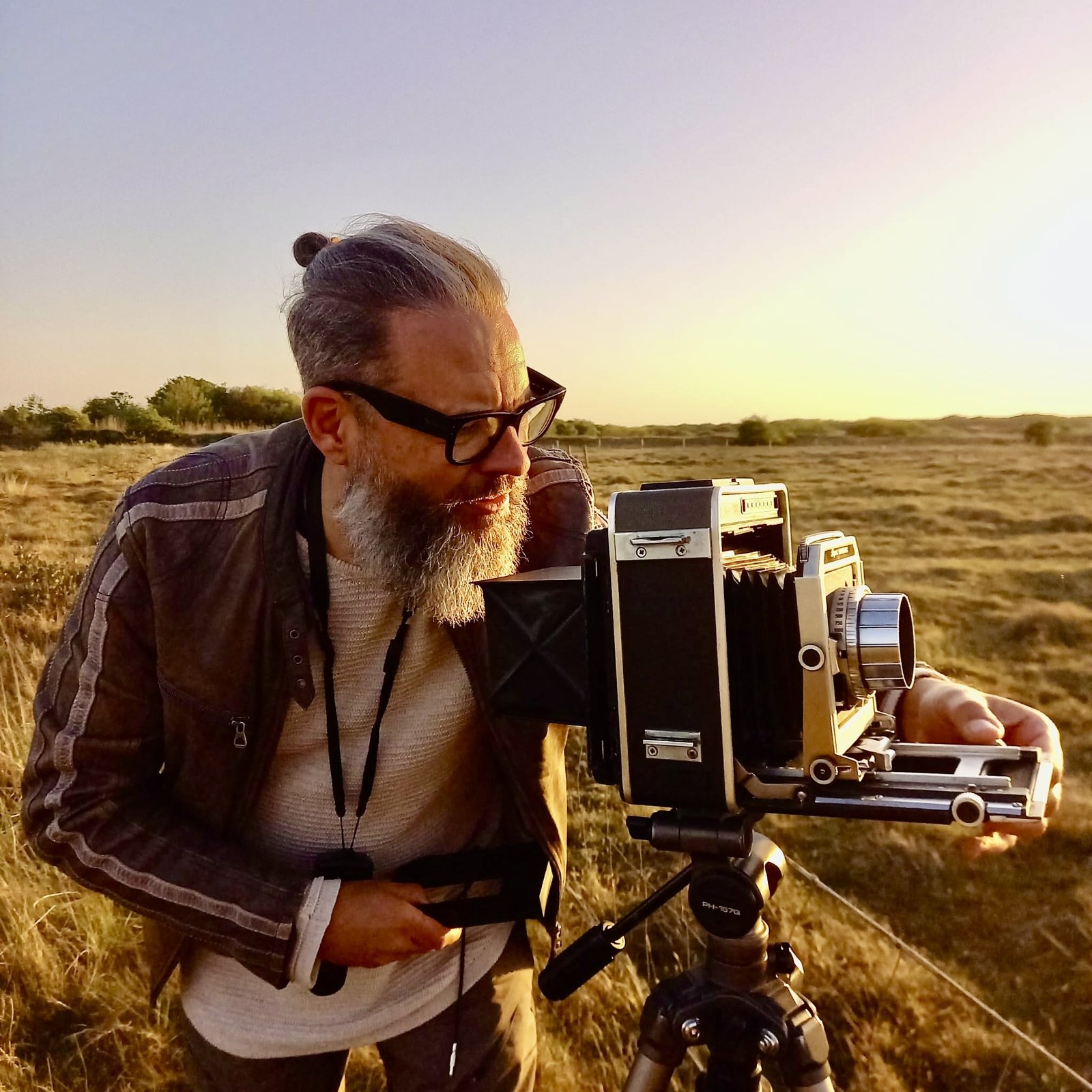 Theodoor Thomas werkt met een 4x5 camera in de duinen bij warm avondlicht